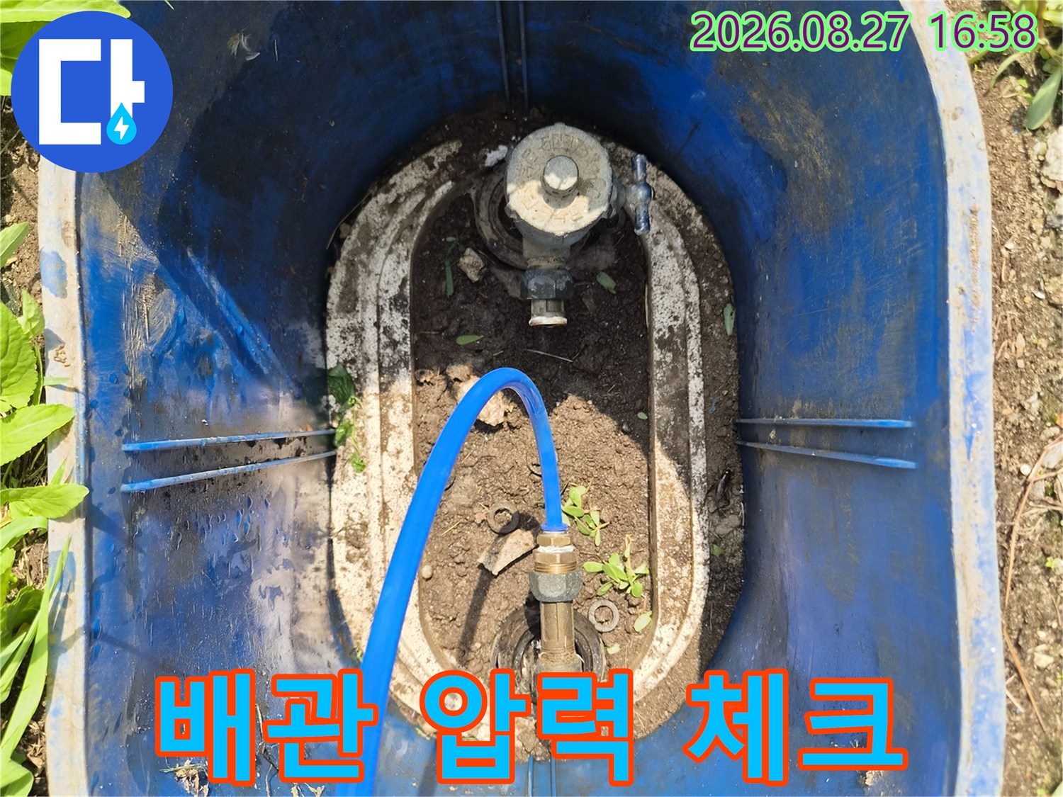 배관 연결 부위에 파란색 호스를 연결하여 압력을 측정하는 장면