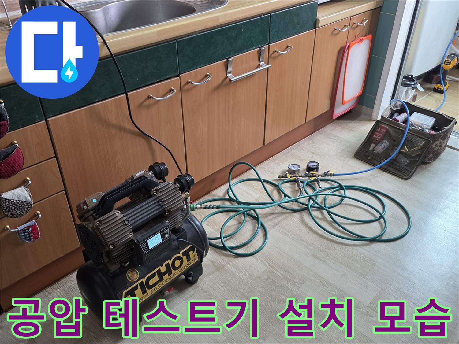 싱크대 하단 배관에 연결된 공압 테스트용 장비와 호스 모습