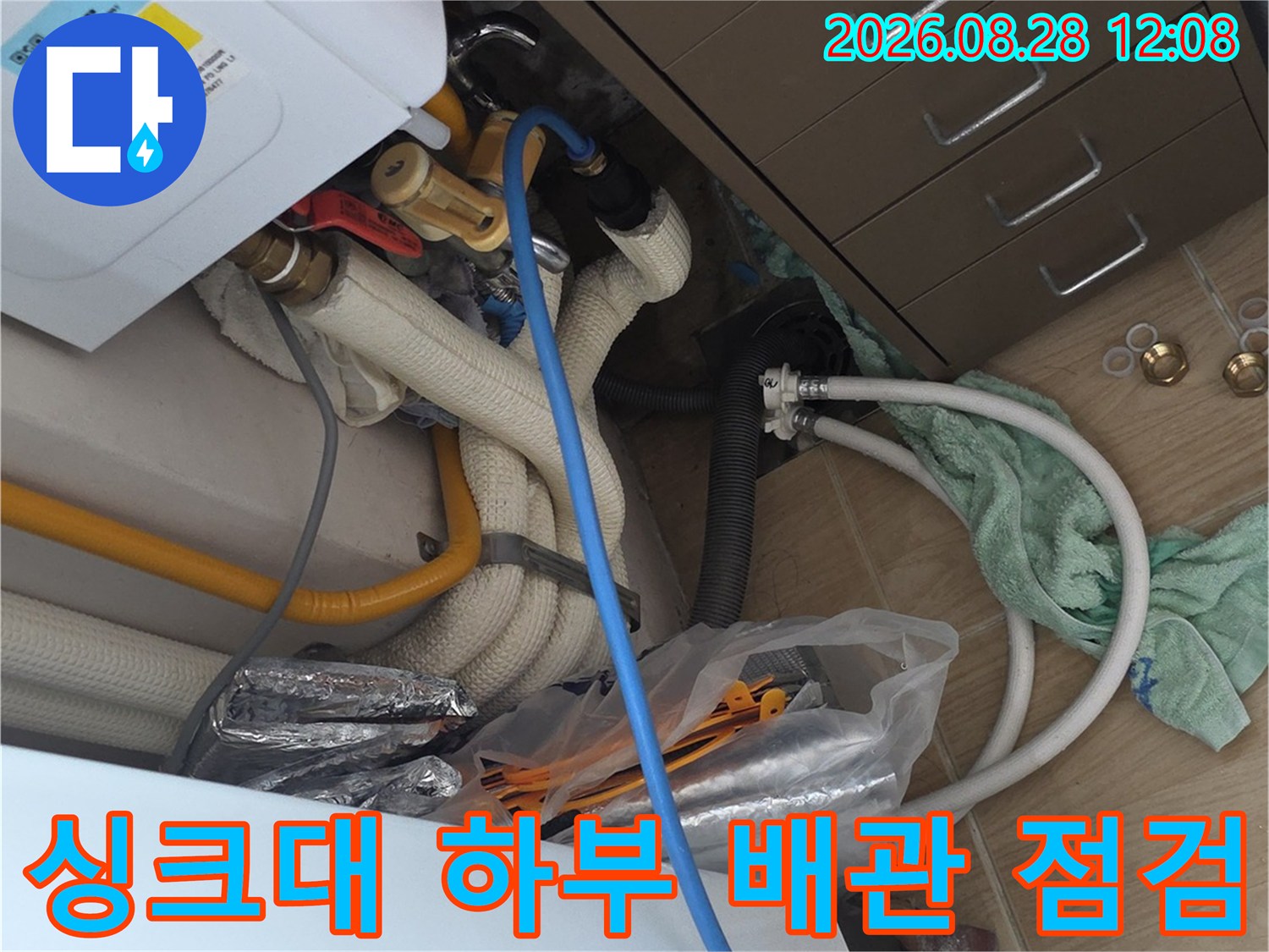 의정부 민락동 아파트 싱크대 하부장의 복잡한 배관과 보일러 분배기 상태를 확인하는 장면입니다.