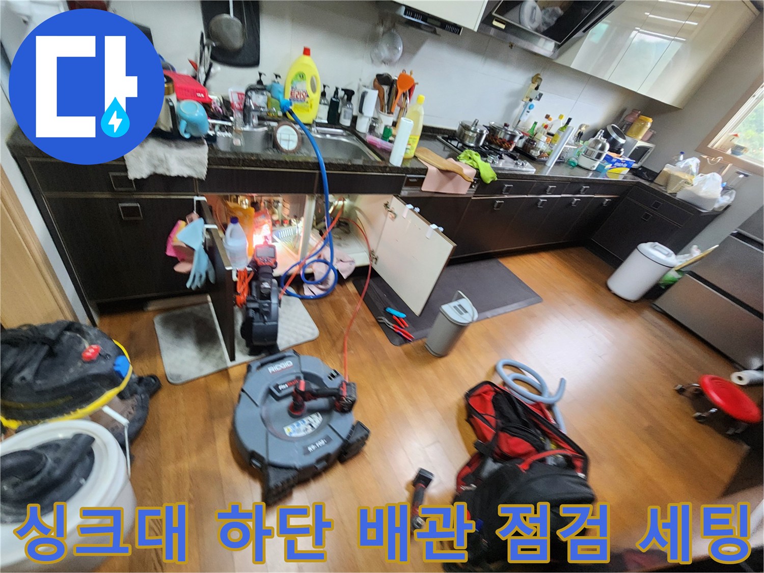 싱크대 아래쪽 배관 상태를 확인하기 위해 배치된 전문 내시경과 작업 도구들