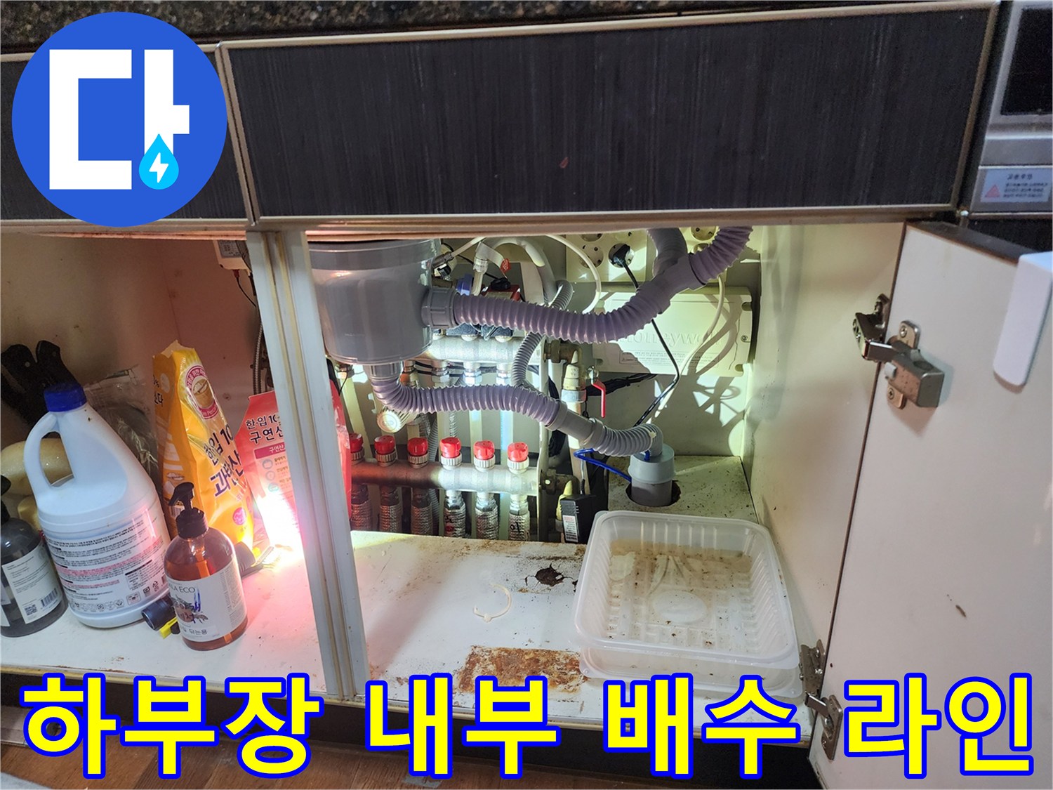 싱크대 아래쪽-여러 갈래로 나뉜 배수 호스와 밸브들