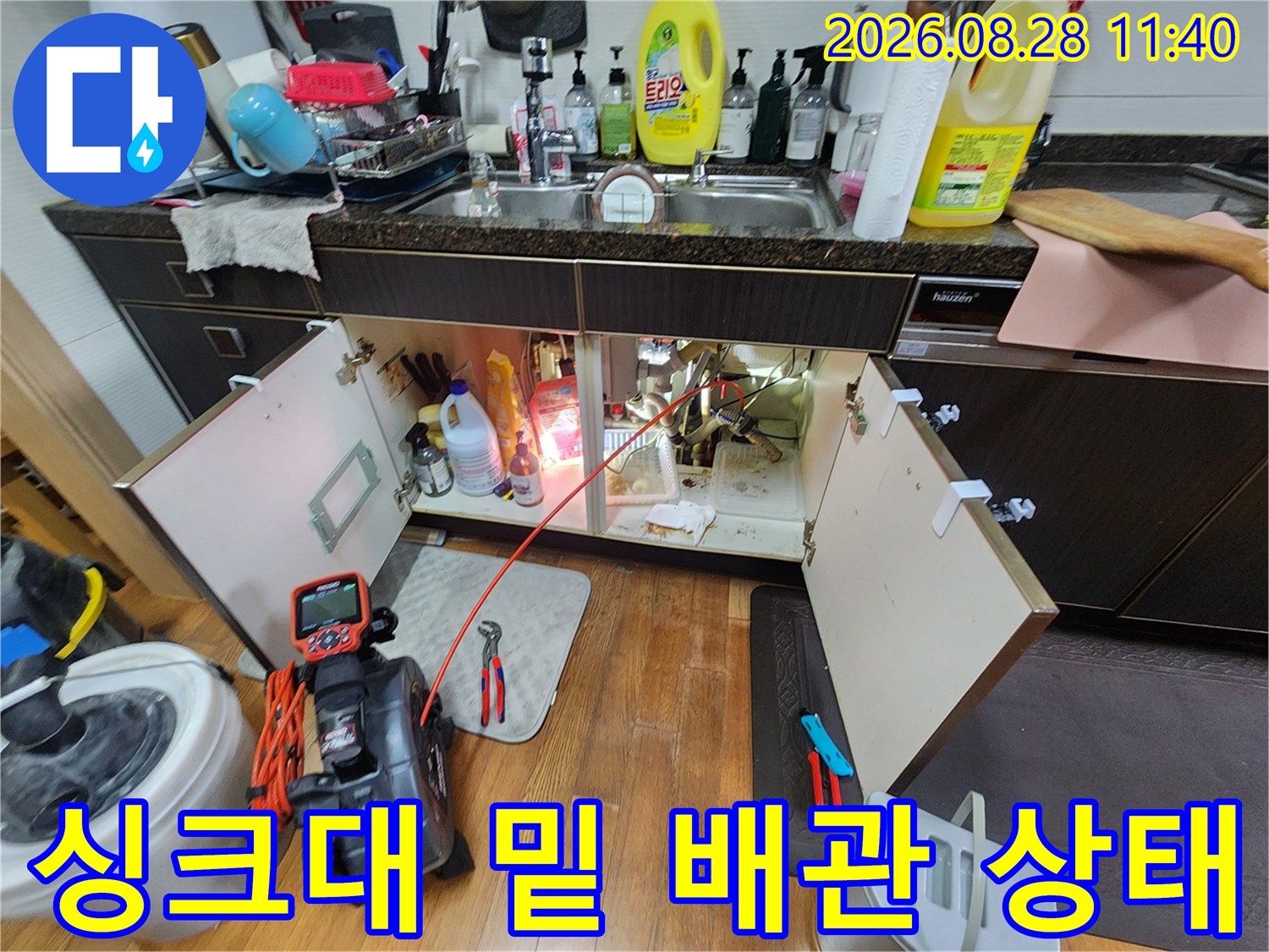 싱크대 하단 배관의 연결 부위와 에어컨 호스 연결 지점을 확인하는 모습입니다.
