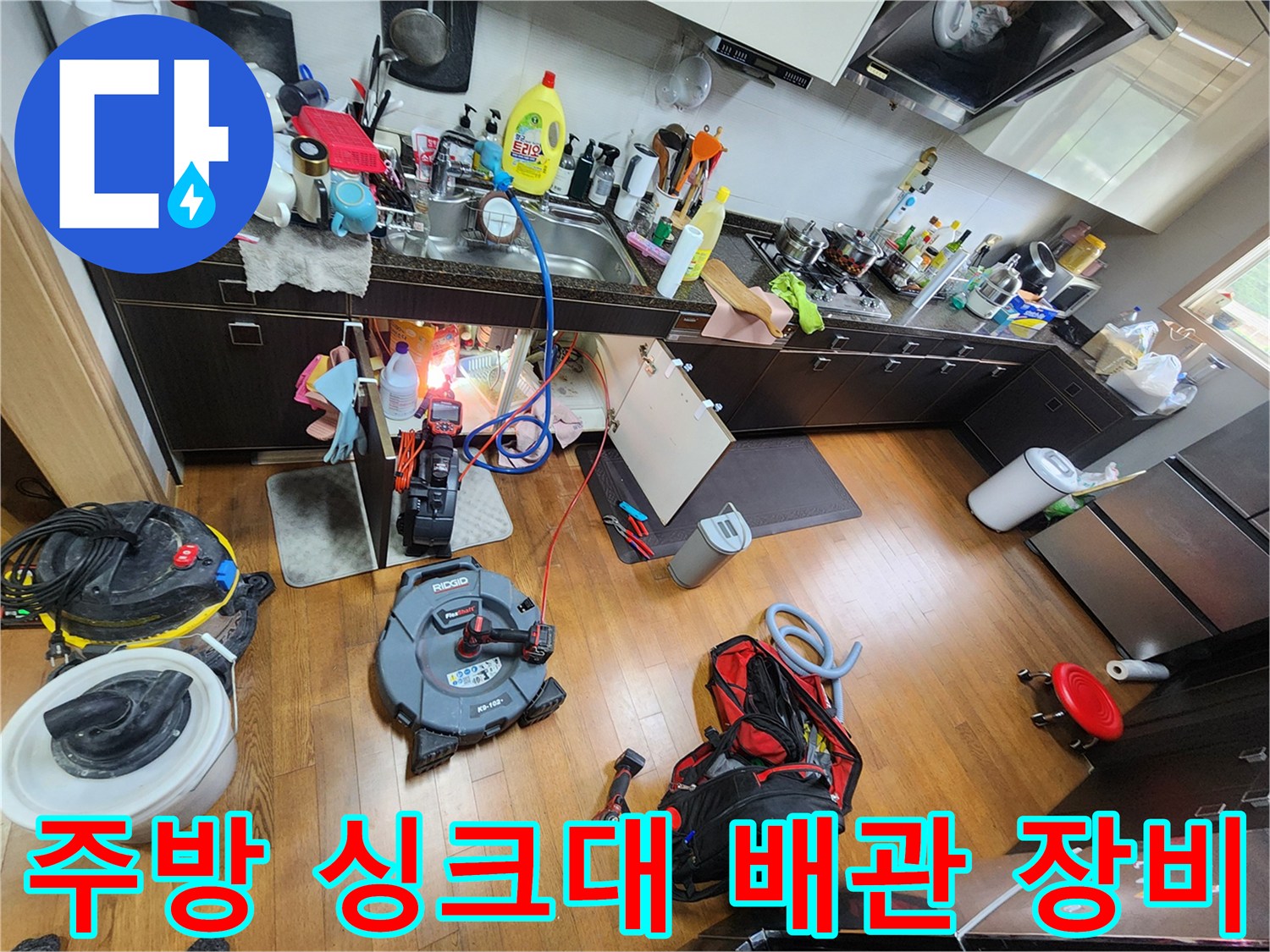 싱크대 하부장 주변에 배치된 배관 점검용 전문 장비들입니다.