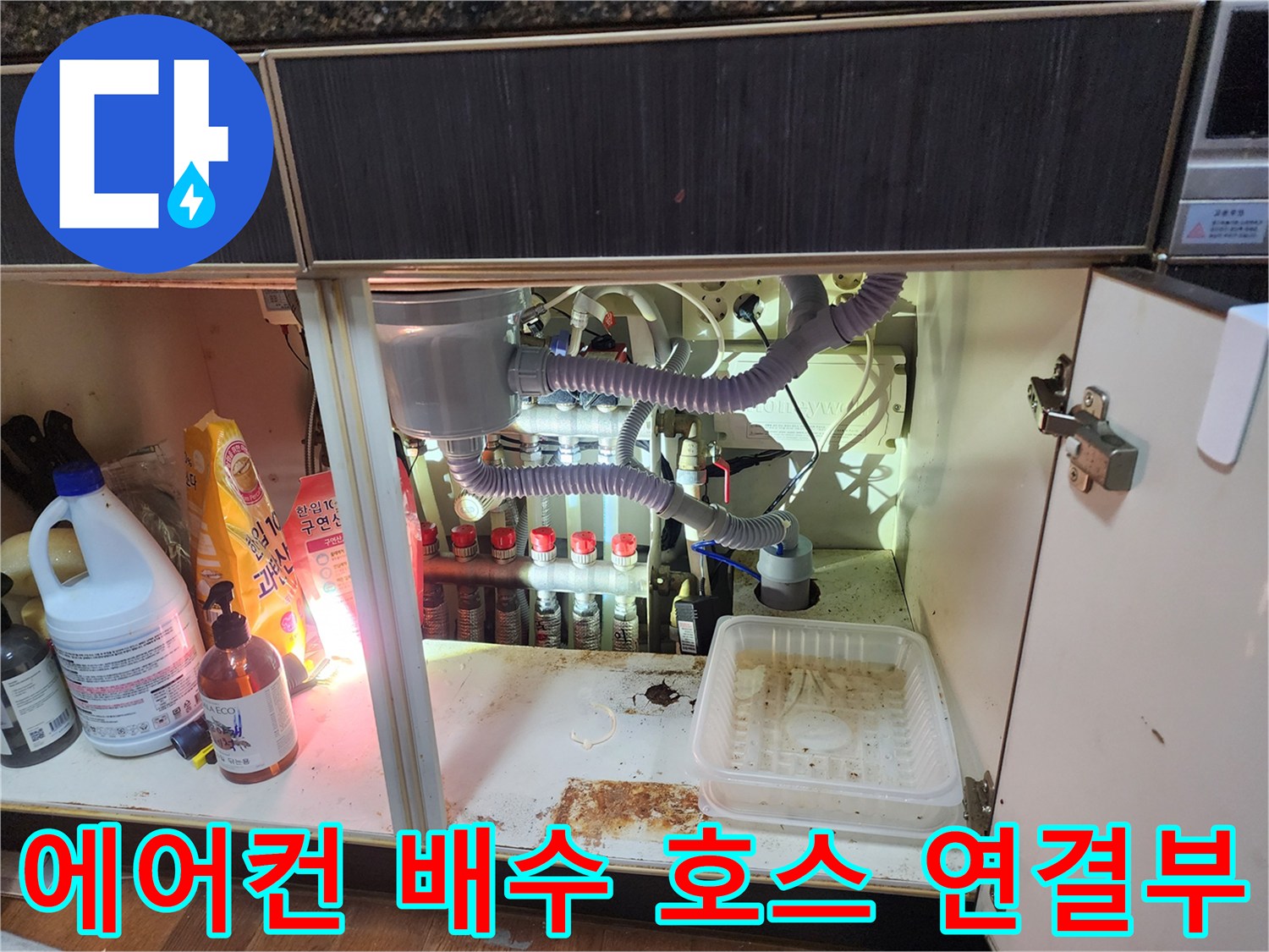 주방 싱크대 하부에 설치된 에어컨 응축수 배수 호스와 연결관