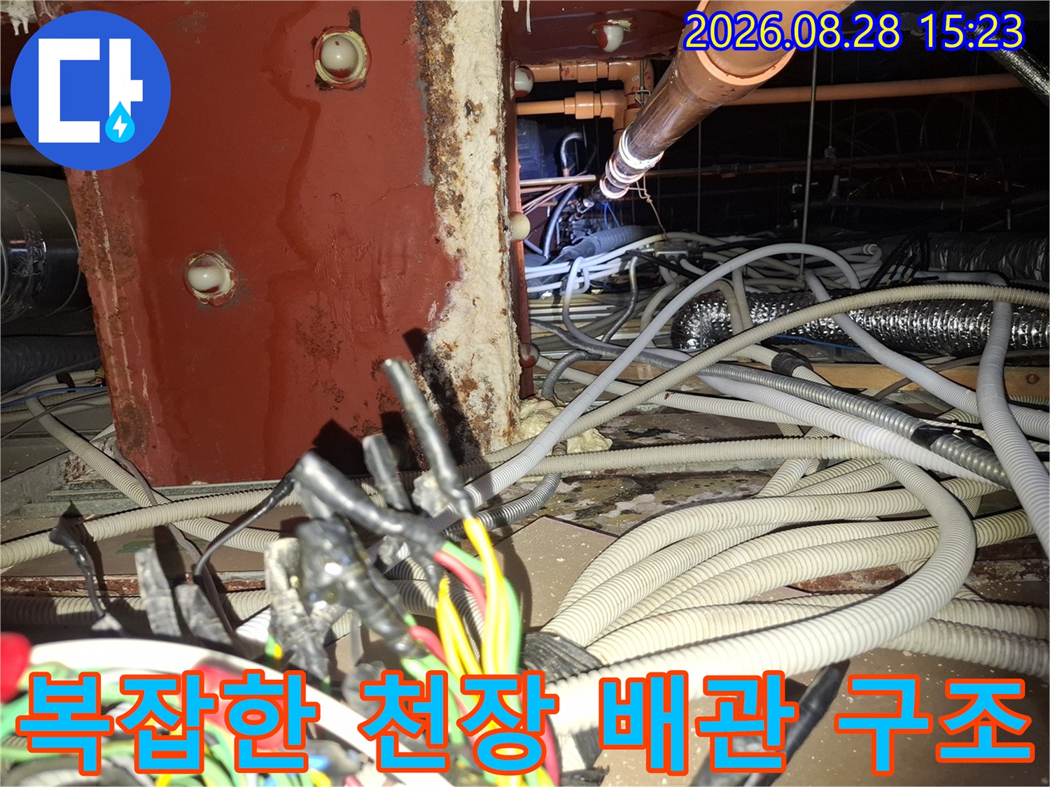 천장 내부의 배관과 전선-누수 점검을 위해 노출된 복잡한 설비 상태
