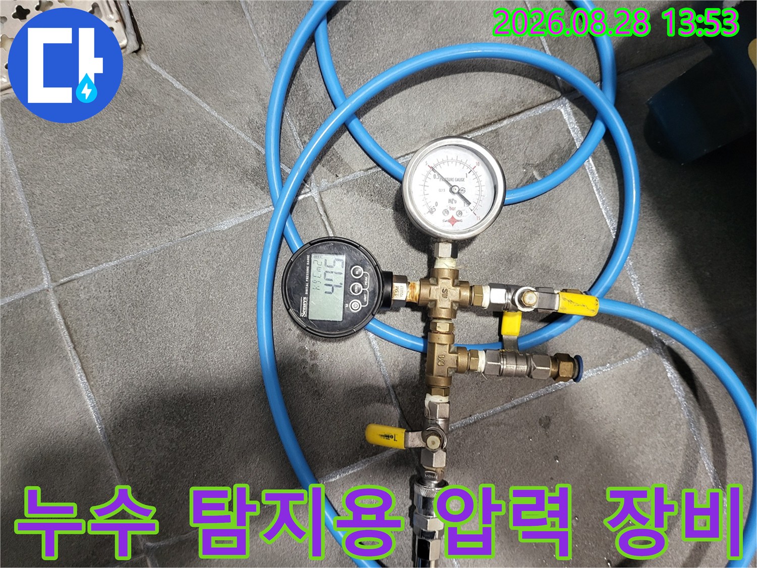 바닥 타일 위에서 진행되는 배관 누수 여부 확인을 위한 압력 측정 작업입니다.