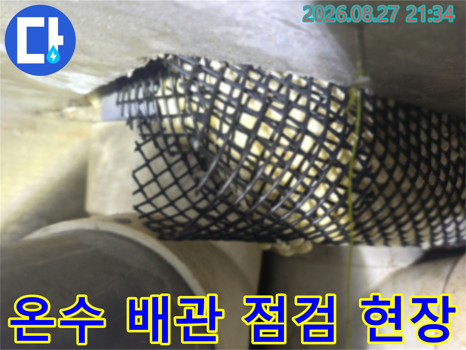 천장 구조물 아래 설치된 검은색 그물망과 배관 연결 부위