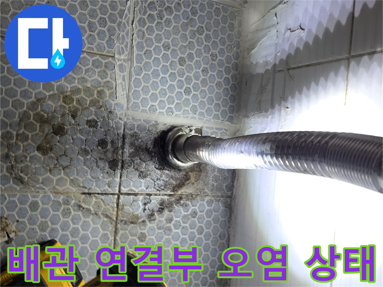 배관 주위의 어두운 얼룩과 젖은 타일 표면