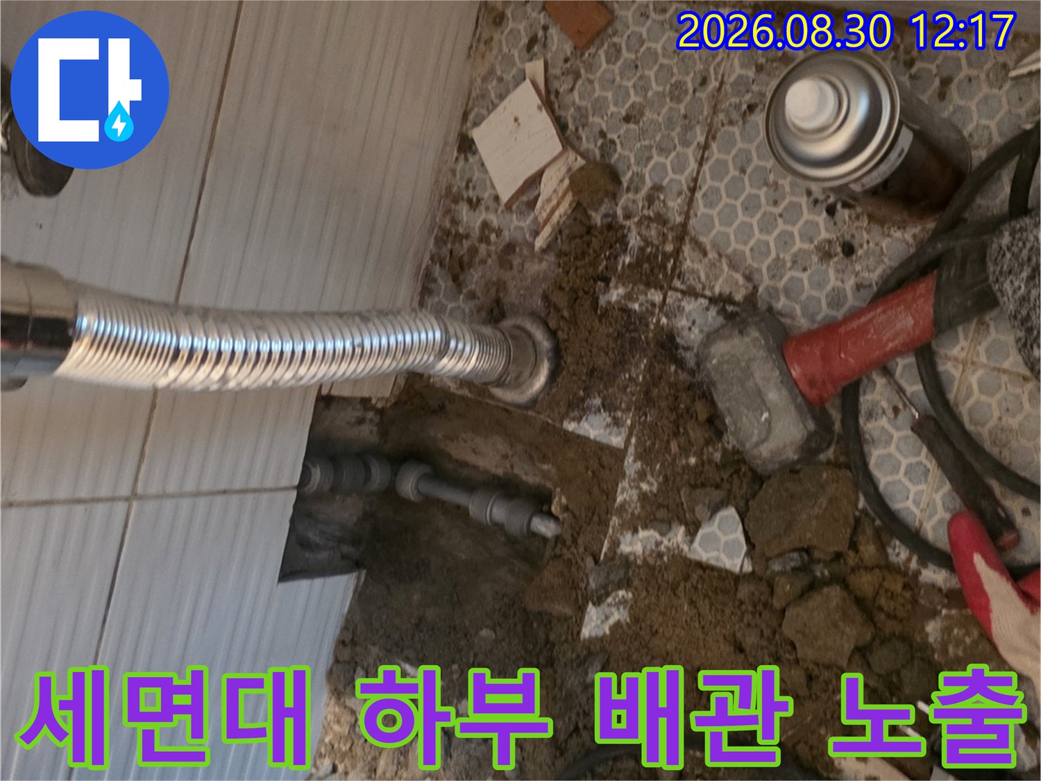 세면대 아래 타일을 제거하여 드러난 누수 의심 배관 부위