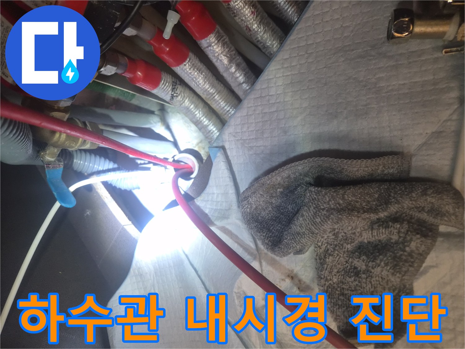 싱크대 하부 배수관 내부의 막힘 상태를 파악하기 위해 내시연 카메라를 활용하는 장면입니다.