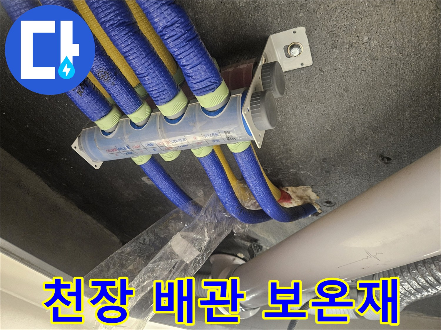파란색과 노란색 보온재로 감싸진 천장 내부 배관 모습