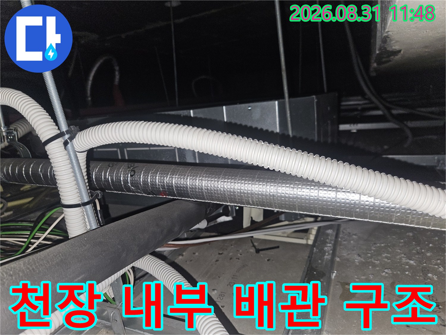 은박 보온재가 씌워진 배관과 흰색 주름 호스가 복잡하게 연결된 천장 모습