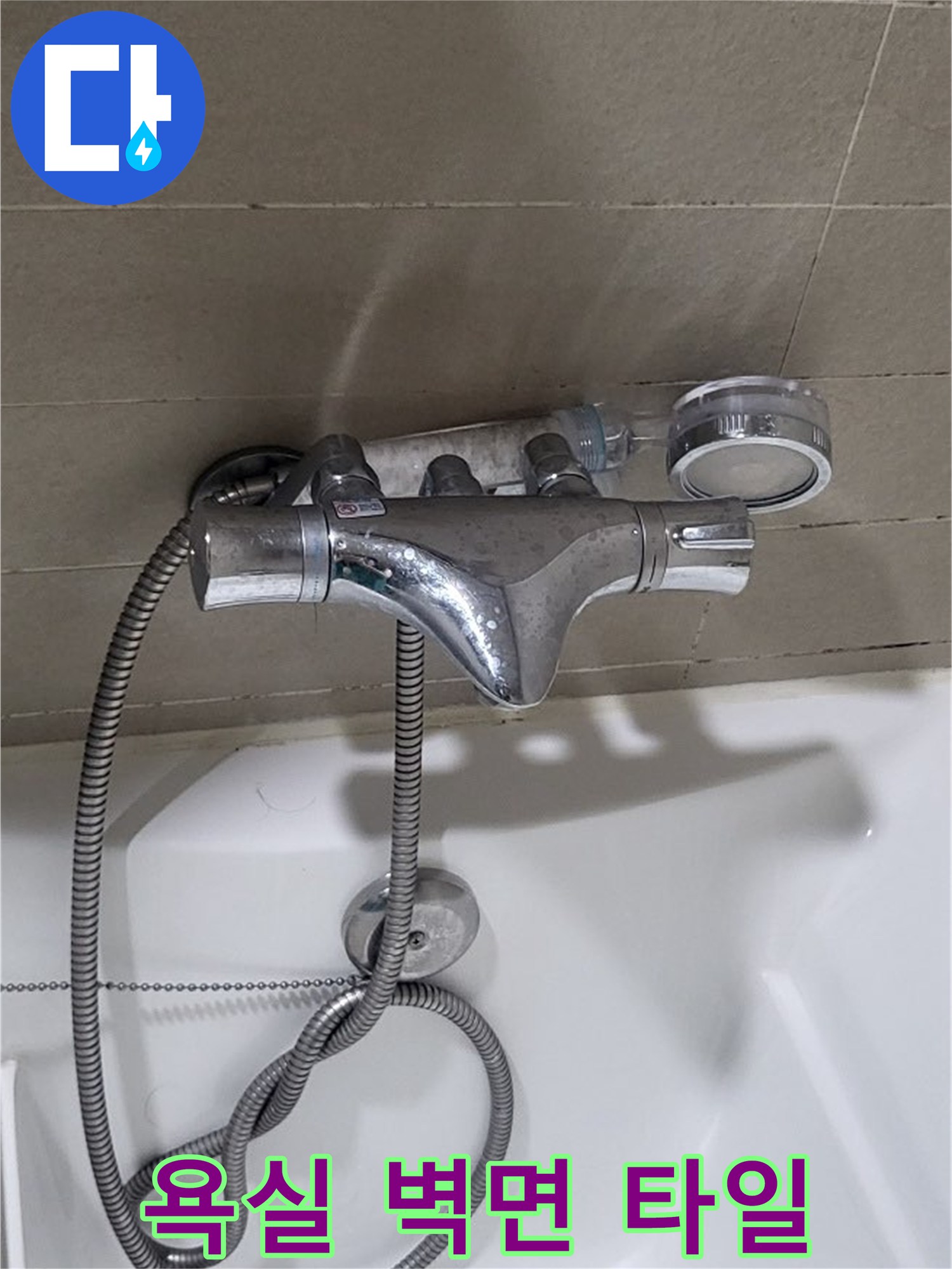 타일 벽면에 설치된 수전과 샤워기 호스 연결 부위