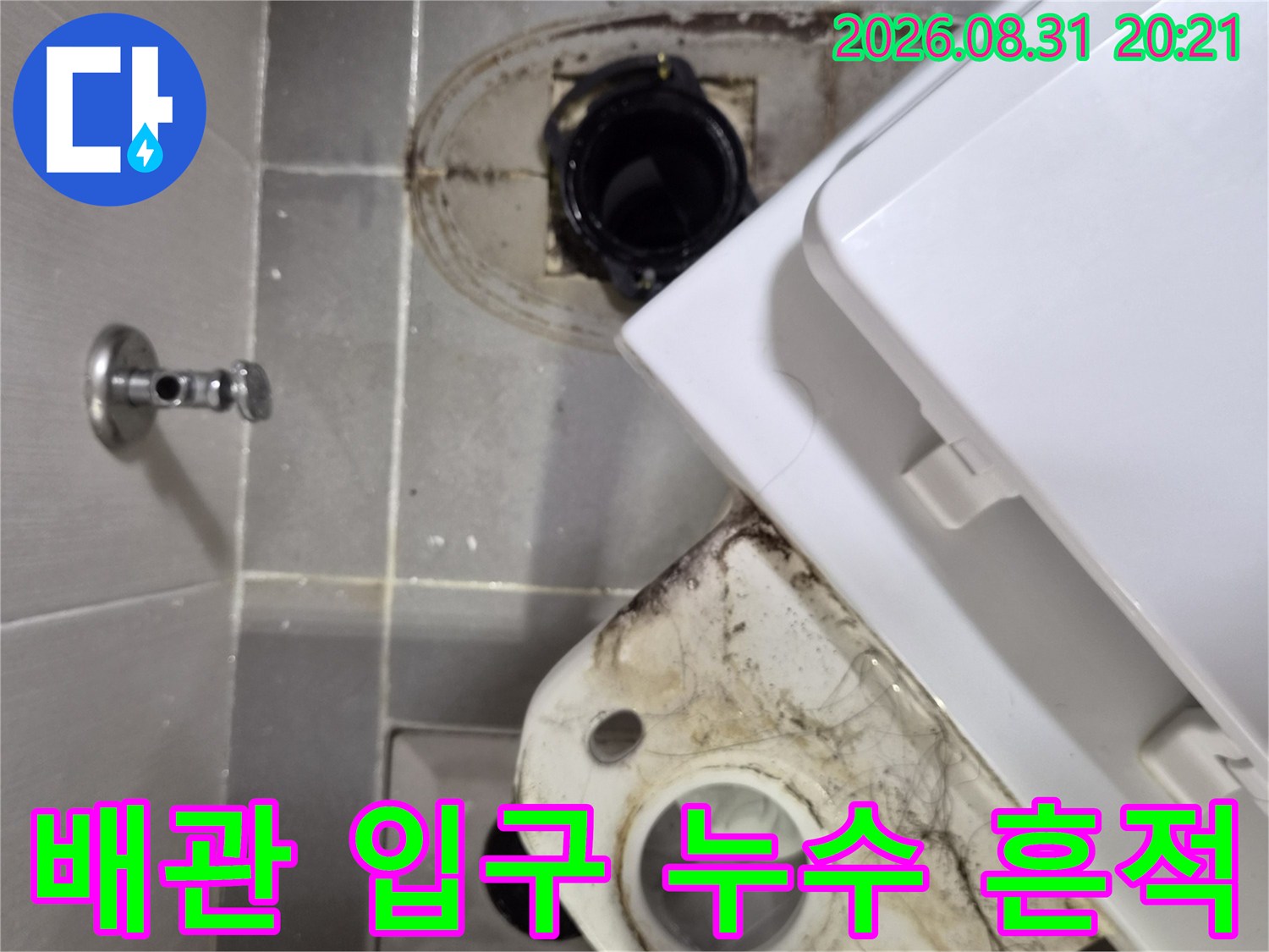 변기 배수관 주변 타일의 변색된 오염 부위