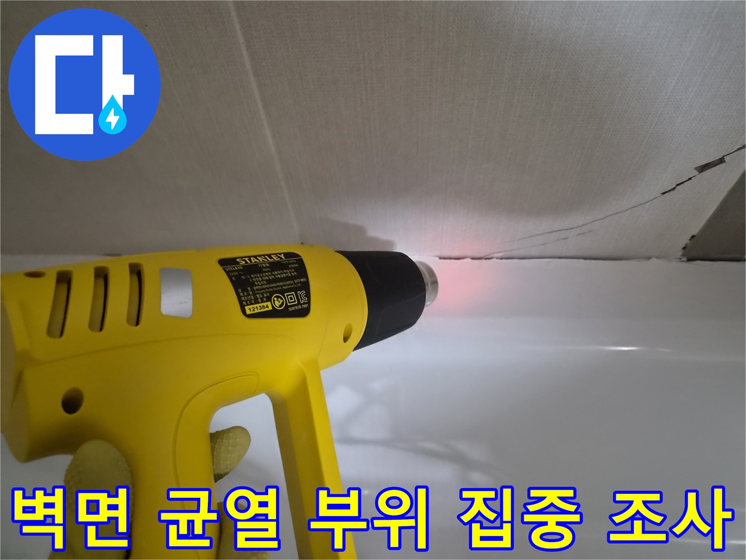 히팅건의 열기를-욕조 경계 틈새에 가해 결함을 찾는 작업 장면