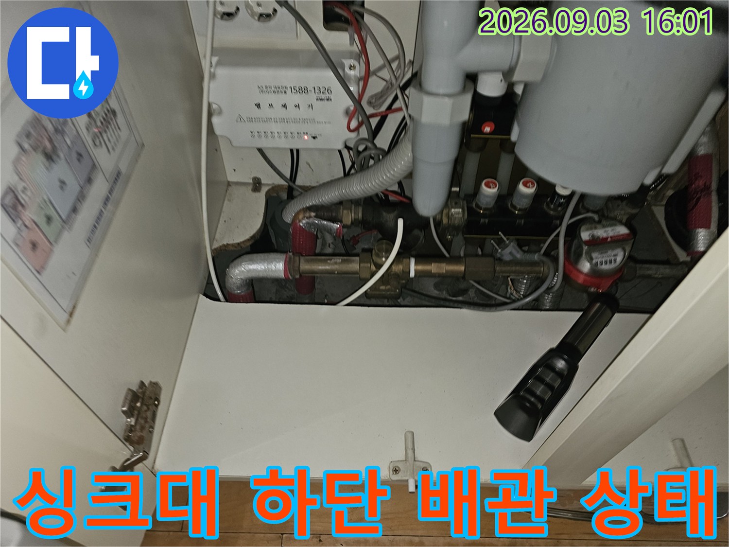 분당 백현동 아파트 싱크대 하단에 복잡하게 연결된 보일러 난방 배관과 분배기 모습입니다.