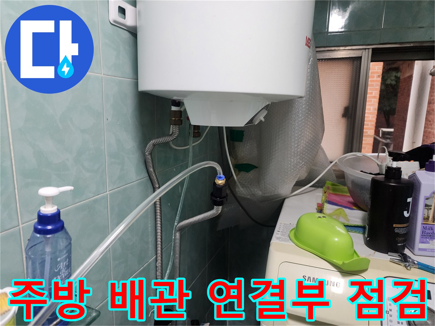 주방 벽면 수도 배관의 연결 부위와 보온재 상태를 확인하는 모습입니다.