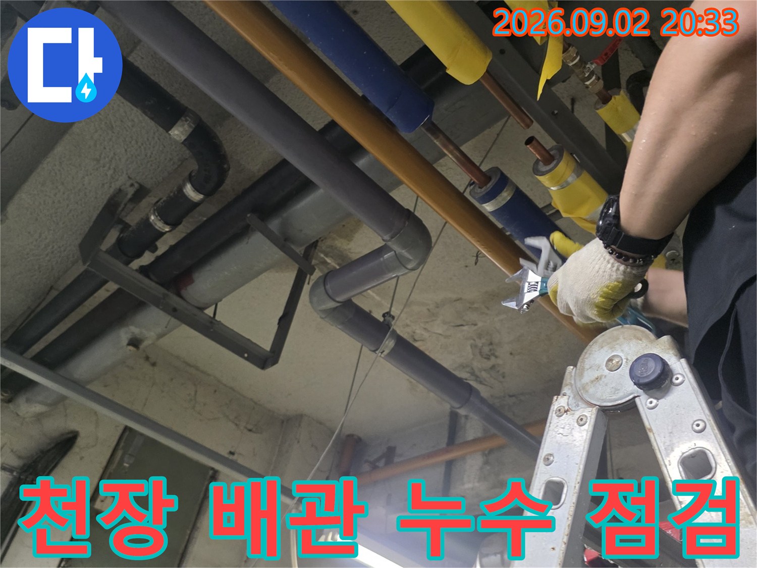 천장 천장에 설치된-배관의 연결 부위를 엔지니어가 직접 확인하고 있습니다.