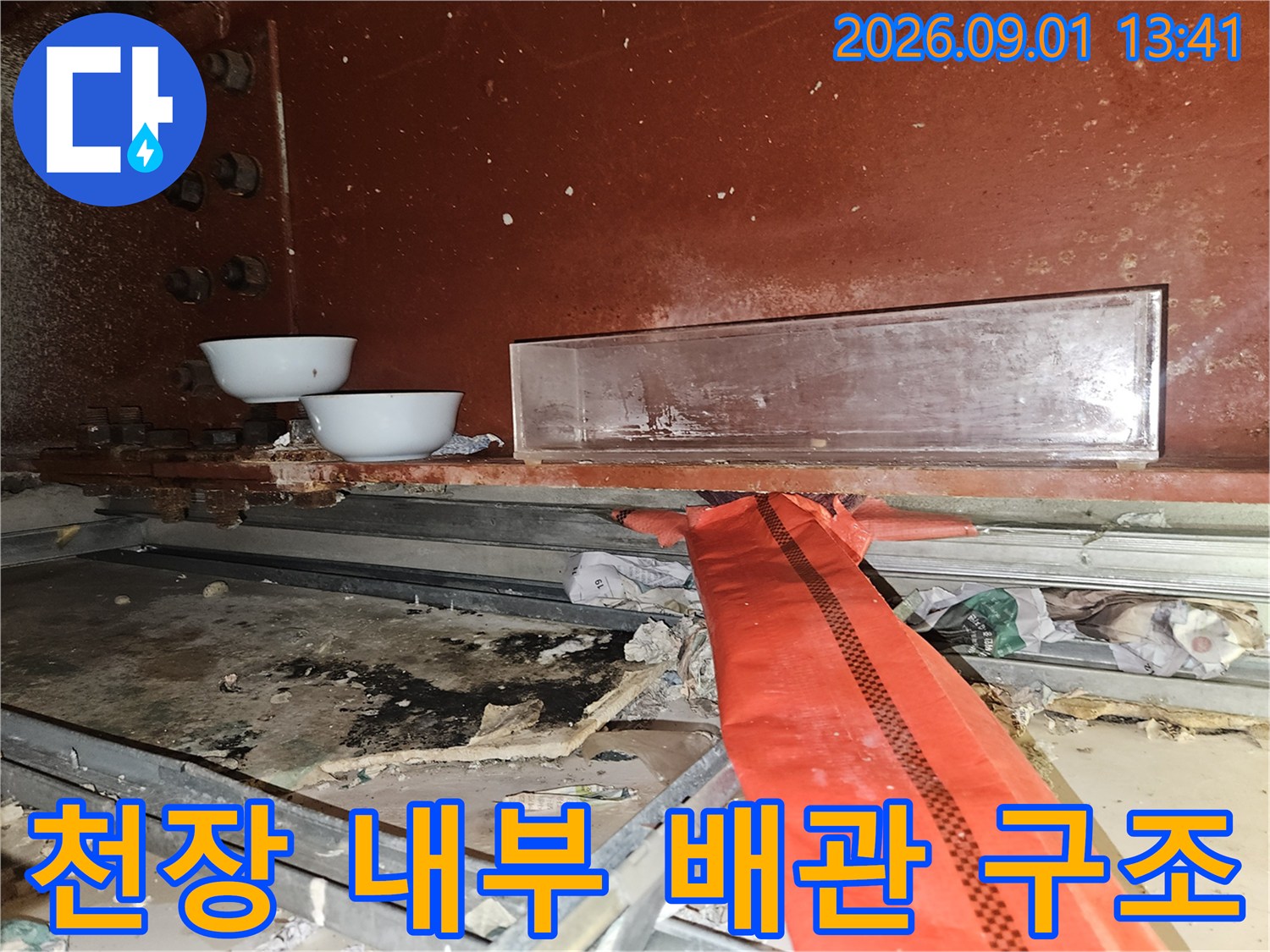 배관 주변의-오염된 흔적과 천장 내부 구조물을 촬영한 사진입니다.