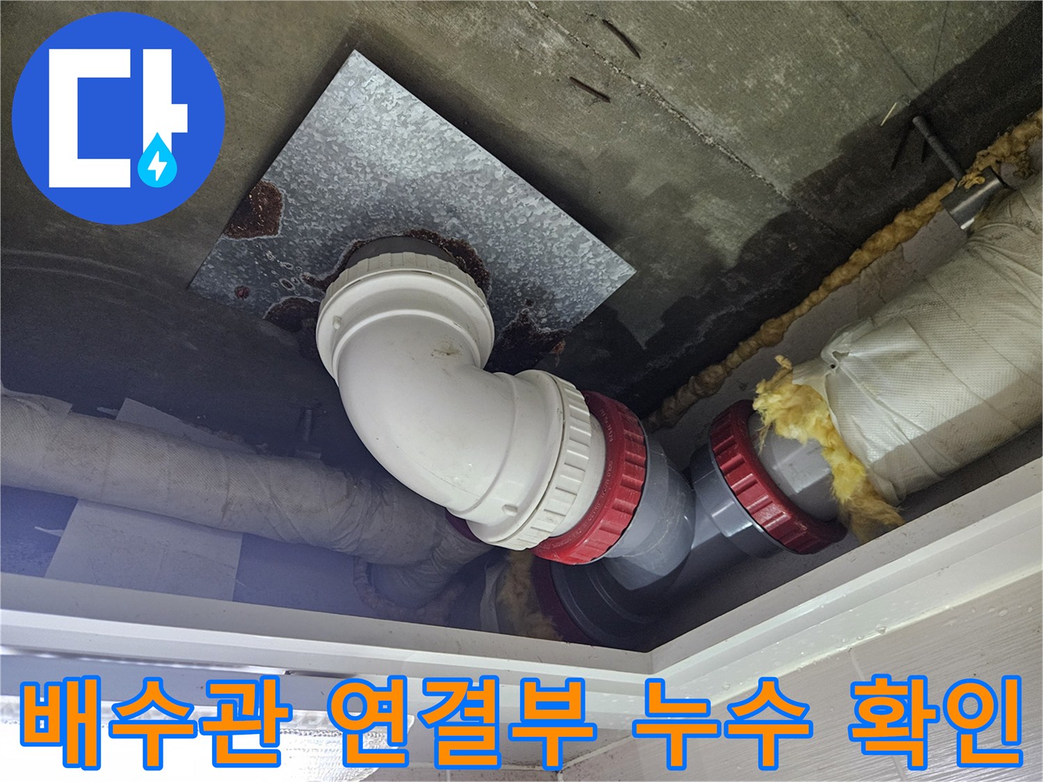천장 배관-습기로 인해 변색된 금속판과 젖은 보온재를 근접 촬영한 모습입니다.