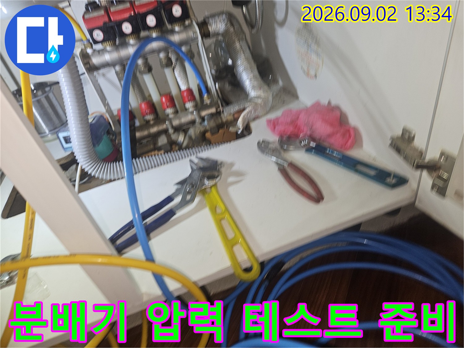 분배기 배관에 연결된 파란색 호스와 작업 도구들입니다.