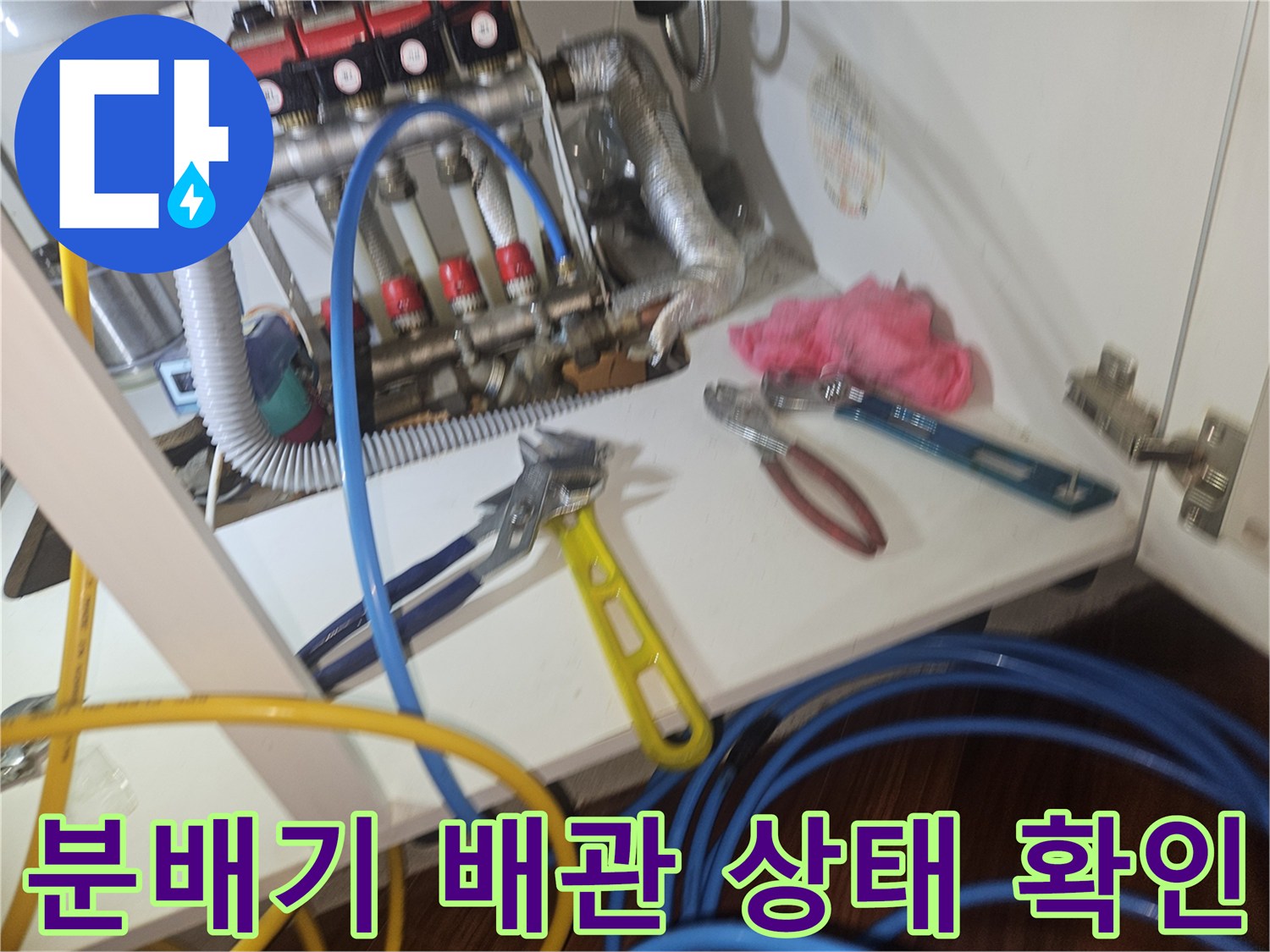 싱크대 아래 설치된 보일러 분배기와 연결된 유연한 배관들