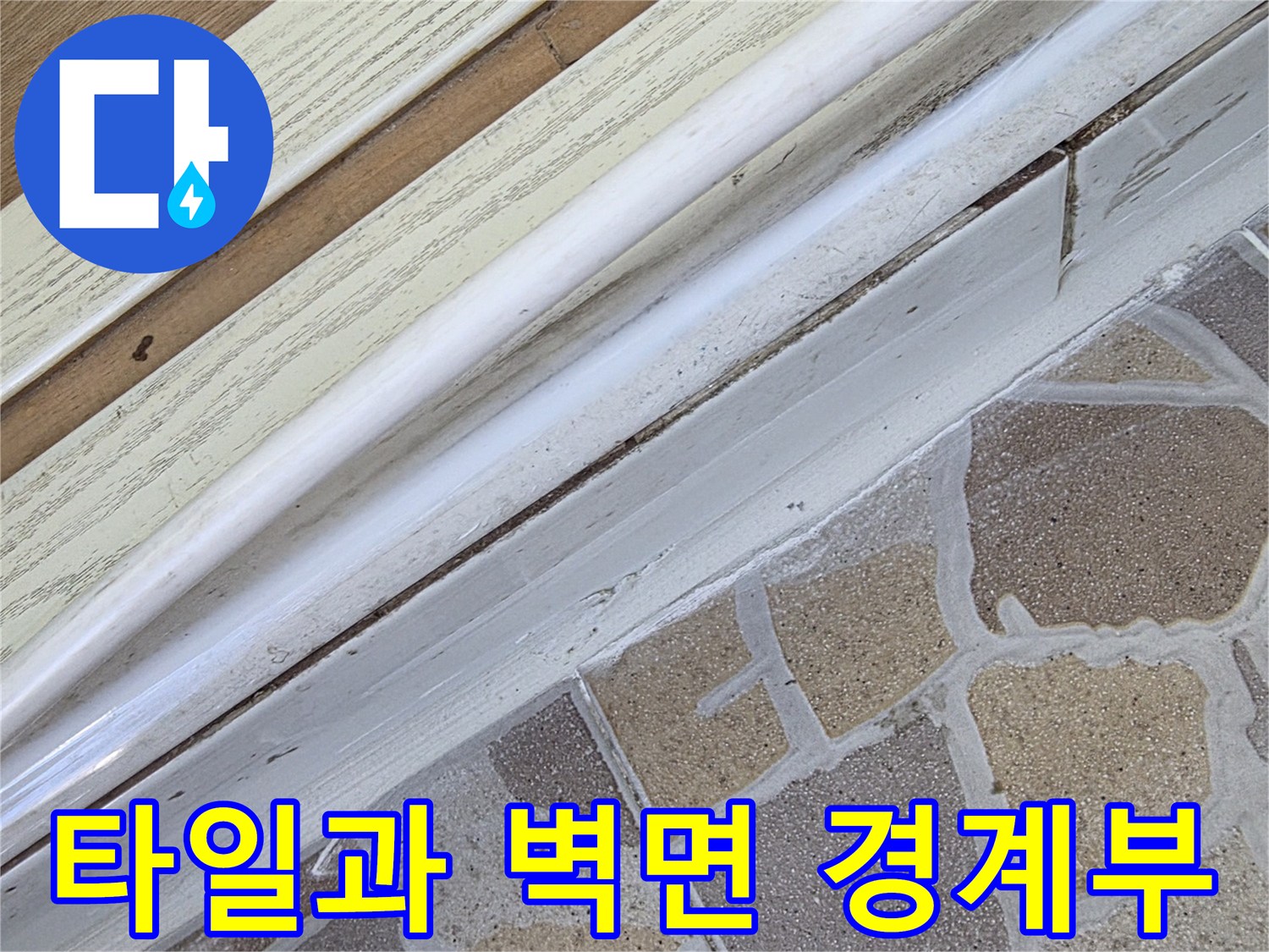베란다 타일과 벽면 접합 부위의 노후된 상태를 근접 촬영한 모습입니다.