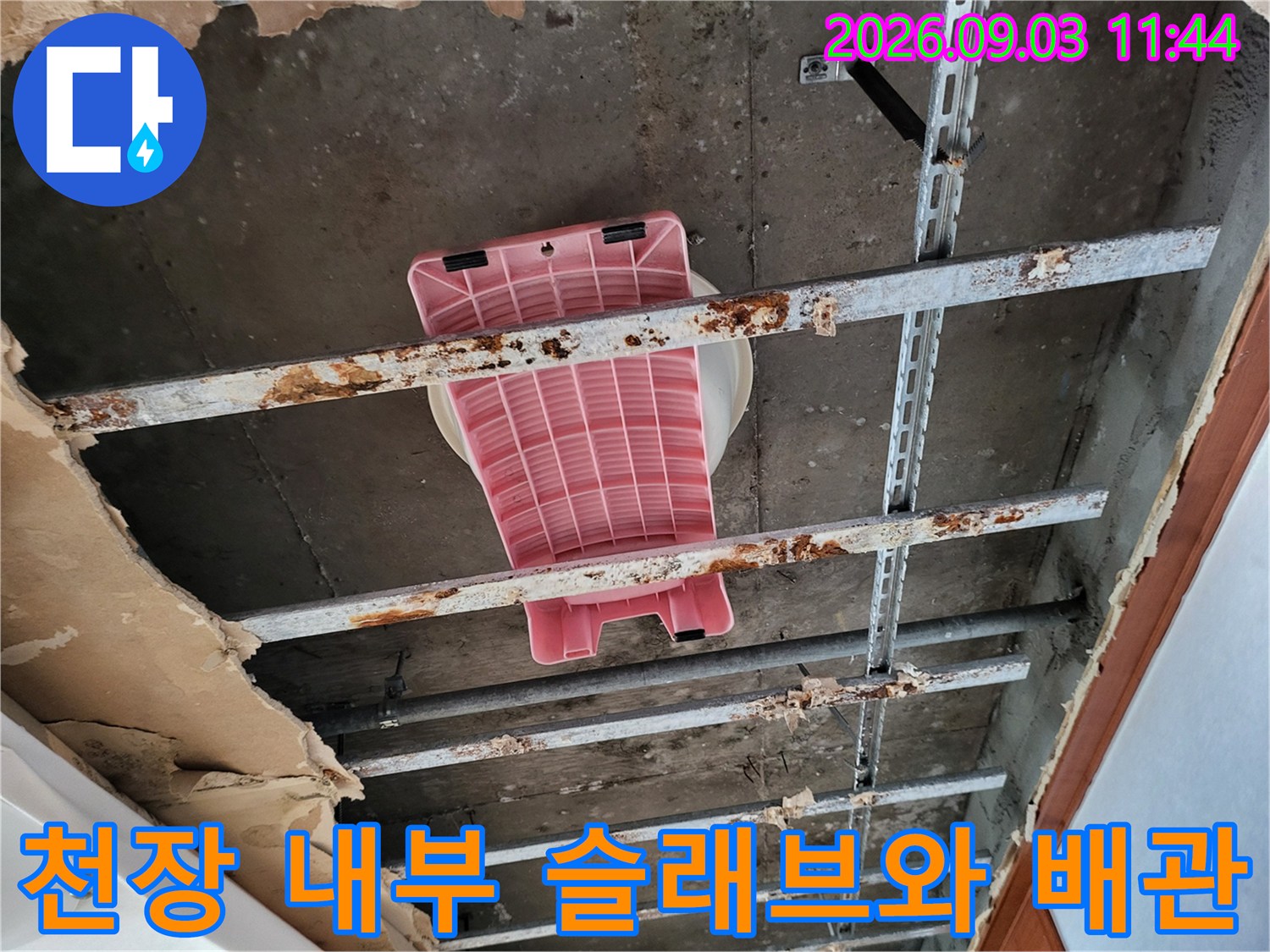 노출된 콘크리트 슬래브와 부식된 천장 지지대 구조물