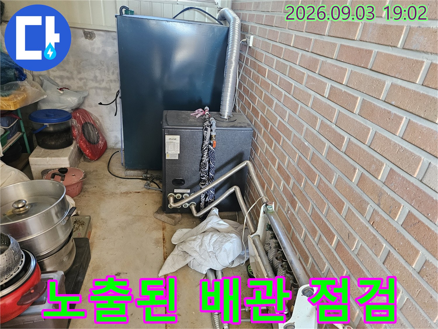 보일러 하단에 설치된 금속 배관과 연결 부위의 상세 모습입니다.