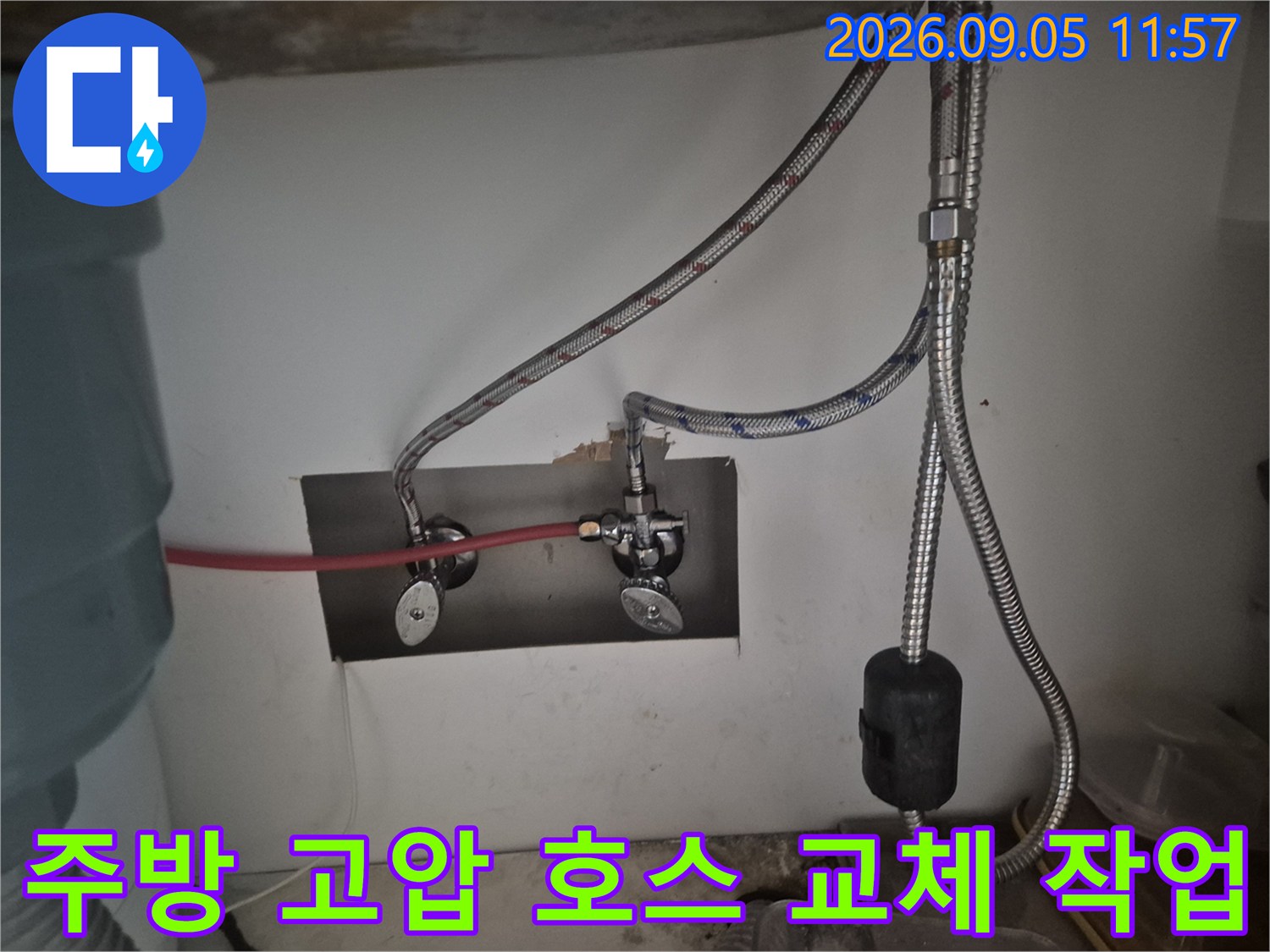 싱크대 하부장 내부의 앵글밸브와 금속 재질의 고압 호스 연결 모습