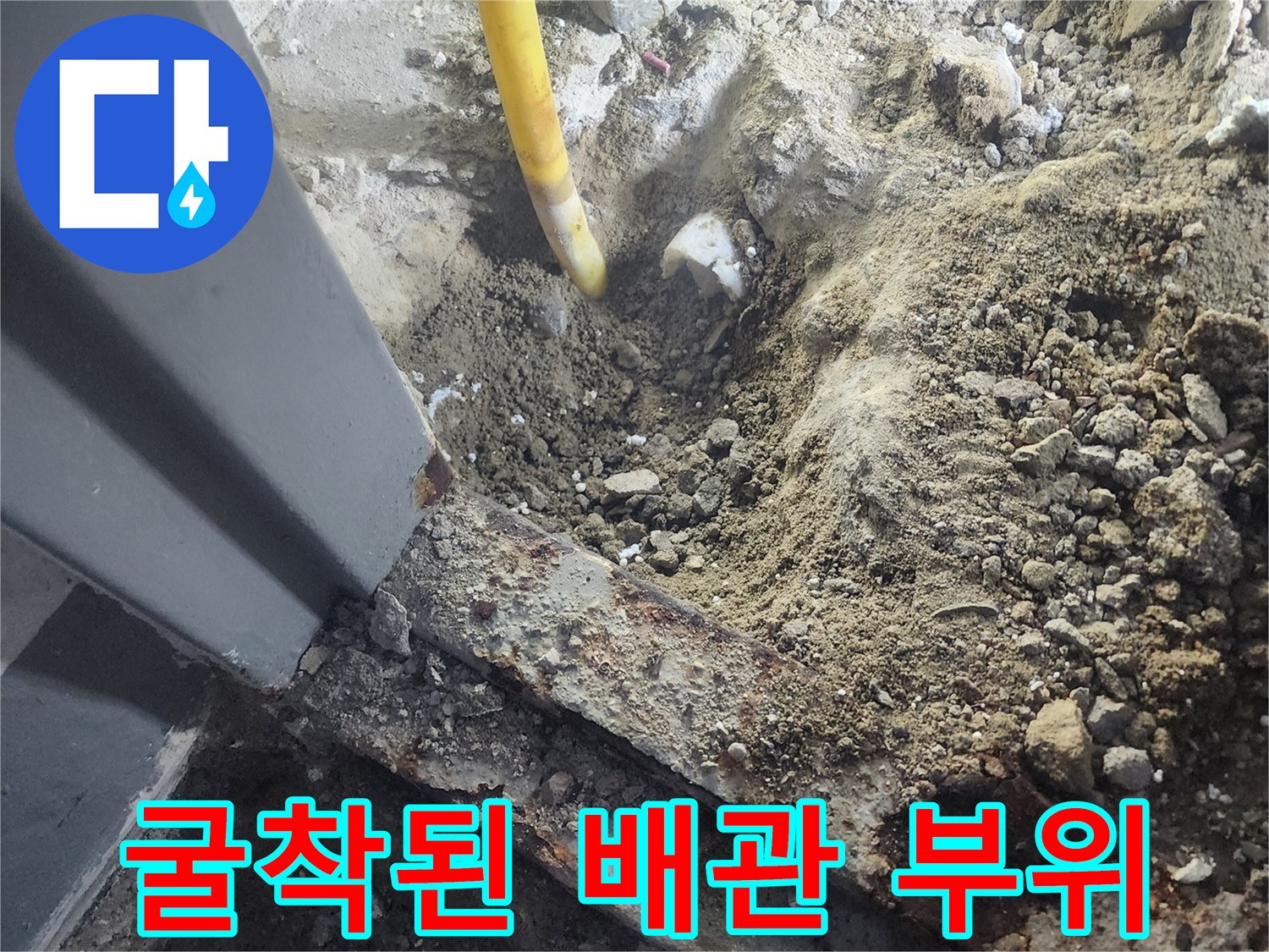 콘크리트 파쇄 후 노출된 노란색 배관의 균열