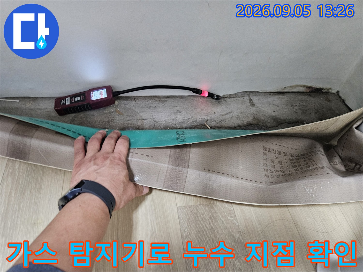 가스 탐지기를 사용하여 벽면 하단 배관의 누수 위치를 추적하고 있습니다.