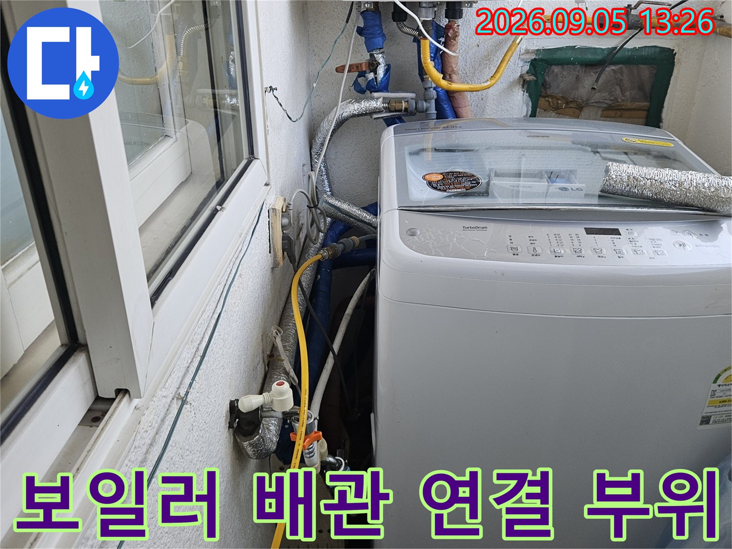 하얀색 보일러 아래쪽에 설치된 여러 종류의 급수 및 온수 배관입니다.