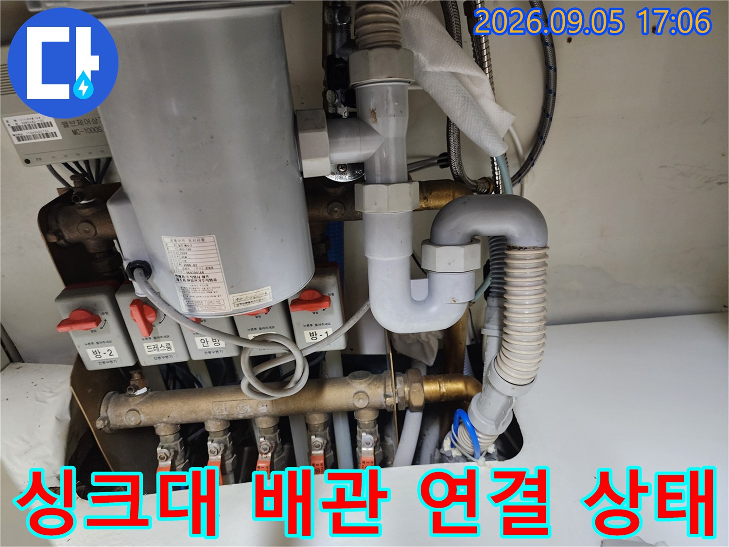 복잡하게 연결된 싱크대 하부 급수 밸브와 배관 부속품들