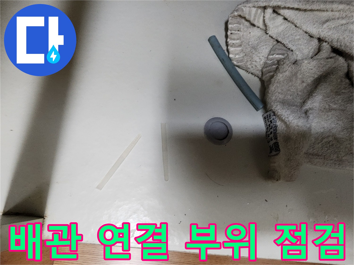 싱크대 하단 배관과 주변 마감재 상태 사진입니다.