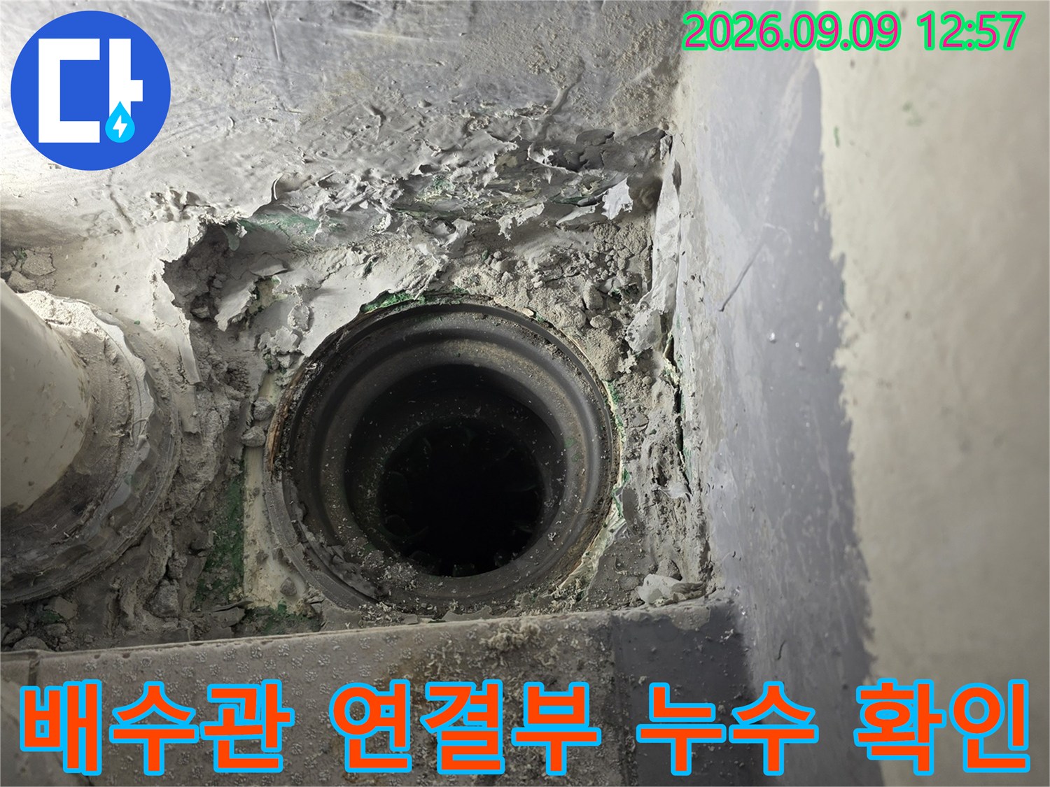 하수구 배수관의 틈새와 파손된 주변 마감재를 촬영한 사진입니다.
