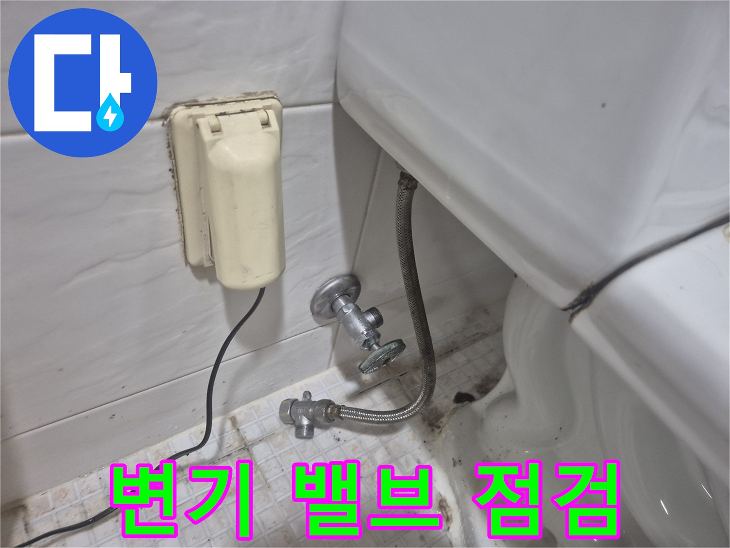 노후된 변기 급수 밸브와 벽면 콘센트 주변의 상태를 보여줍니다.