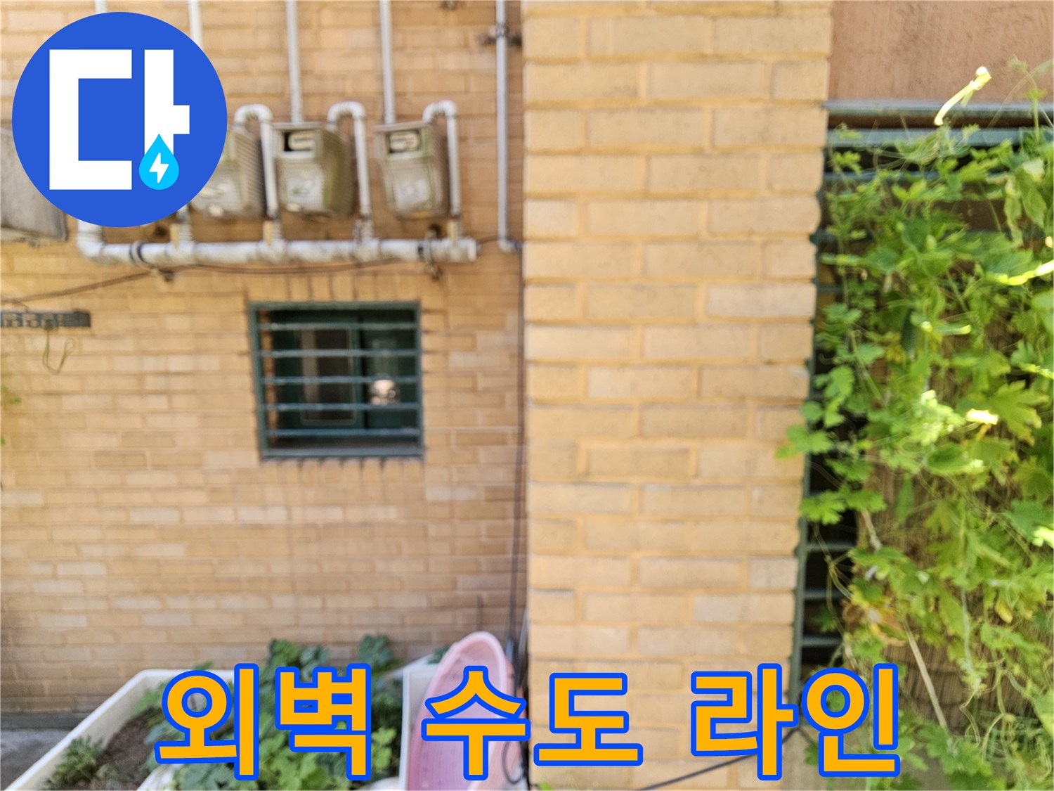 벽돌로 된 건물 외벽에 설치된 여러 개의 수도 계량기와 배관 구조