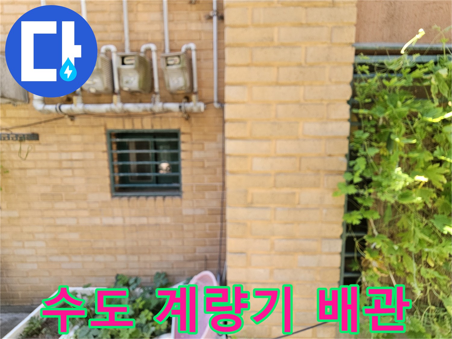 외벽에 설치된 다수의 수도 계량기와 연결된 백색 배관