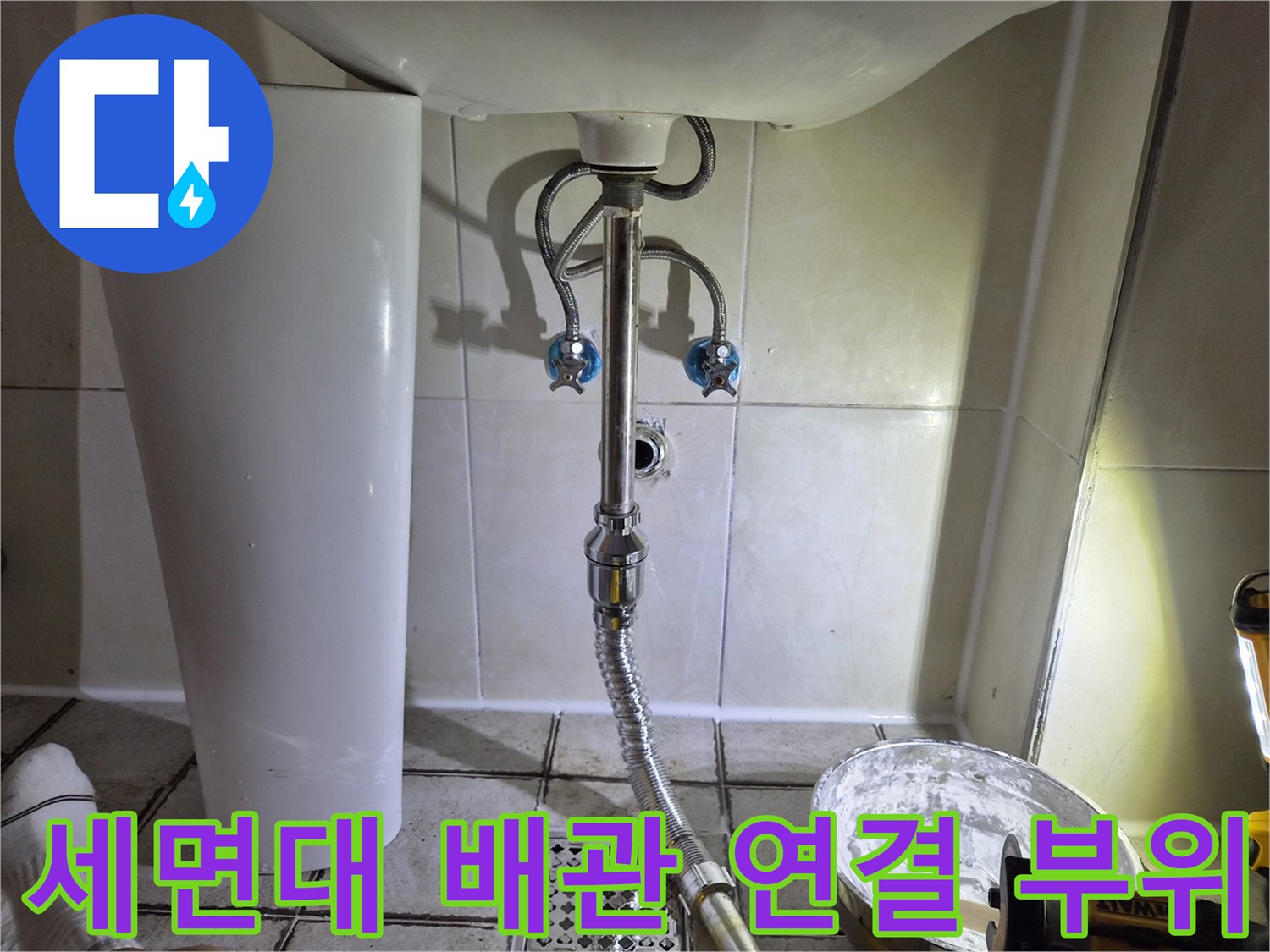 세면대 아래쪽 배수 트랩과 벽체 타일 접합부