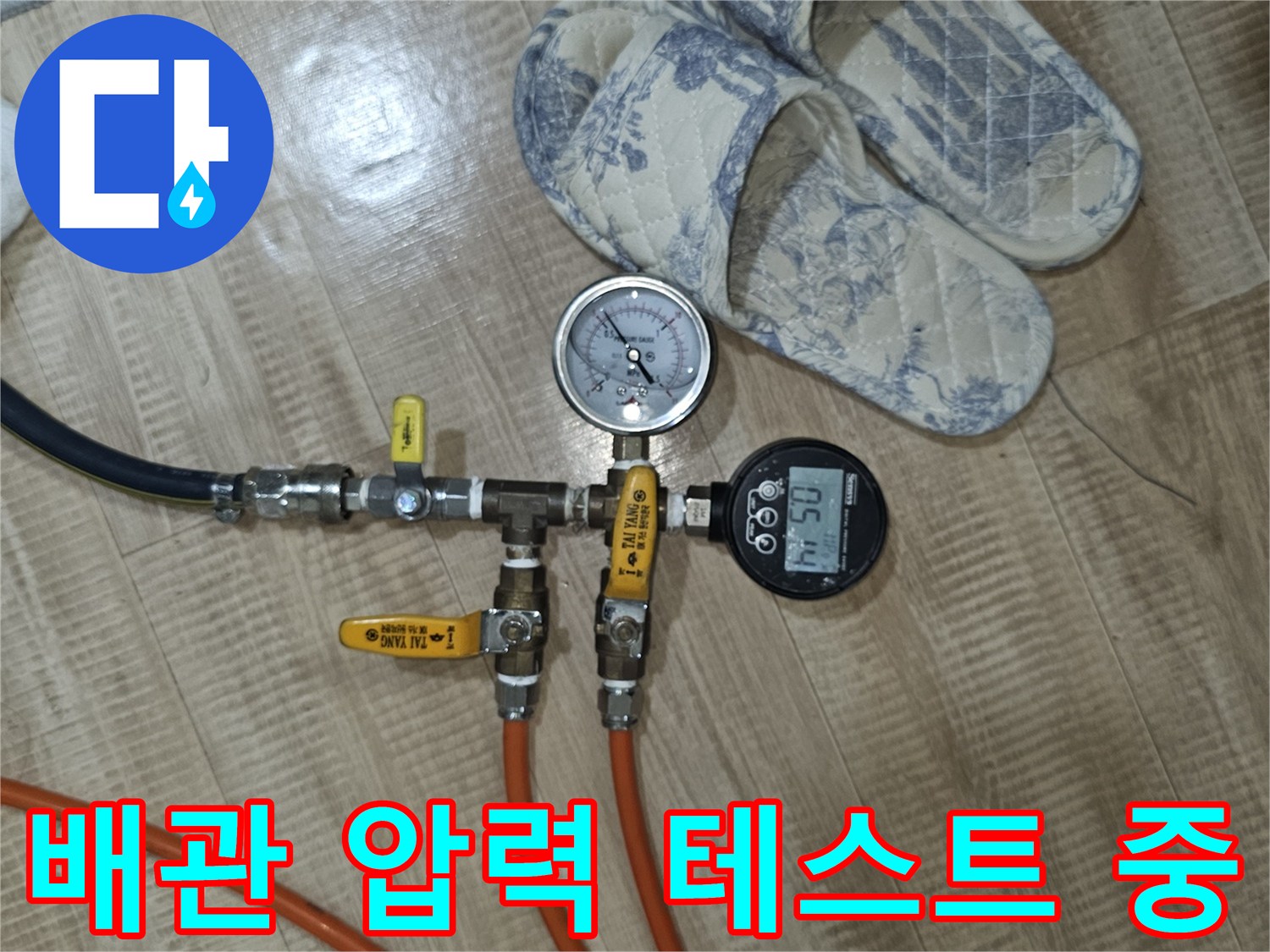 온수 배관의 공압 테스트를 위해 디지털 게이지와 호스를 연결한 모습