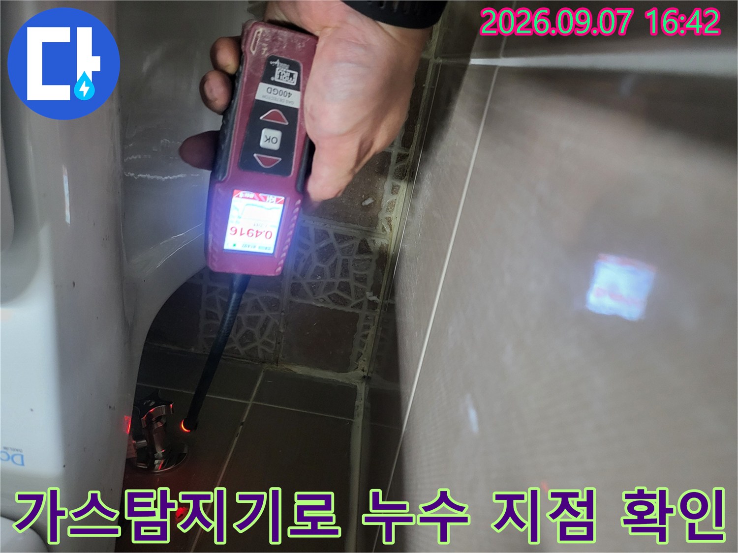 변기 주변 배관 누수를 찾기 위해 가스 탐지기를 사용하는 모습