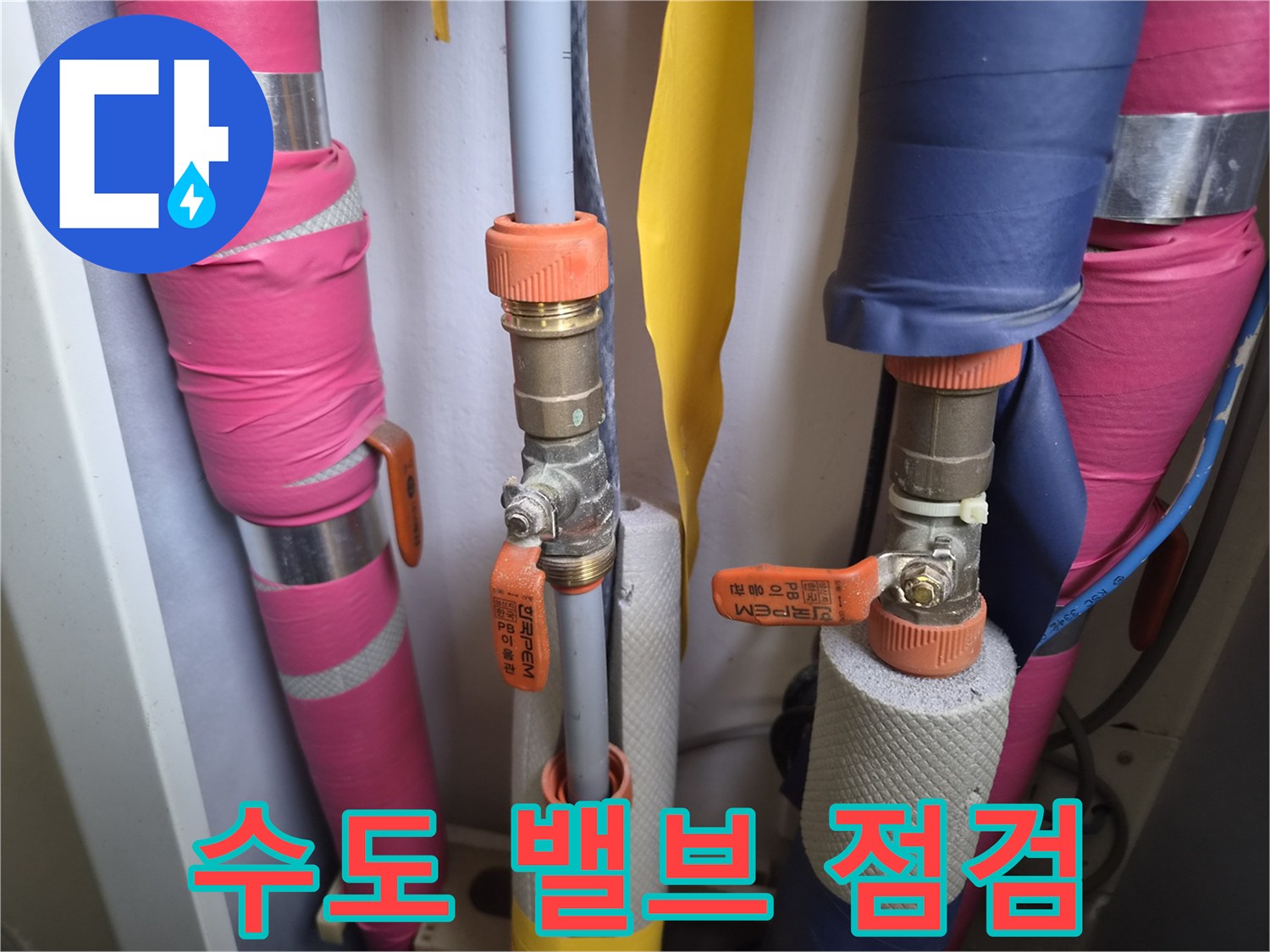 주황색 손잡이가 달린 밸브와 보온재가 덮인 배관 이미지입니다.