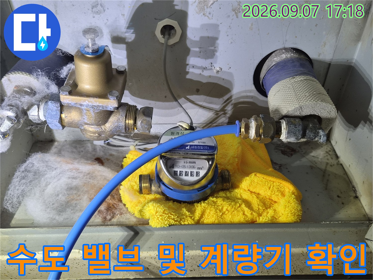 황동 소재의 수도 밸브와 계량기가 설치된 배관 내부의 모습입니다.