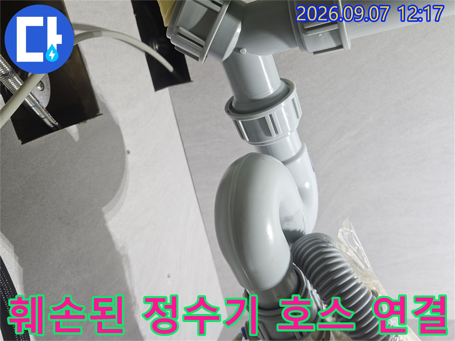 정수기-호스가 테이프로 임시 고정되어 누수가 발생하는 싱크대 배관 내부