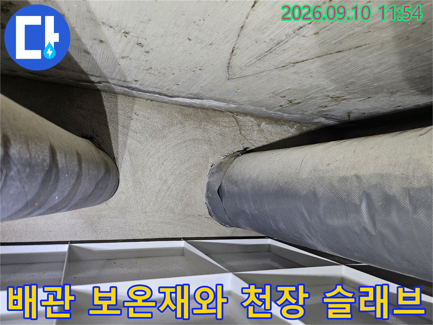 보온재로 감싸진 배상 배관과 콘크리트 천장면