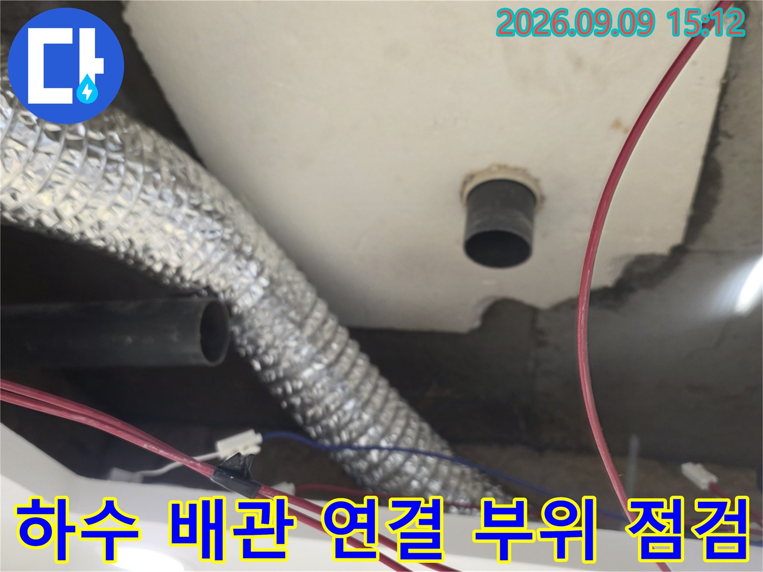 천장 슬래브 아래 설치된 은색 보온 배관과 검은색 배관의 교차 지점