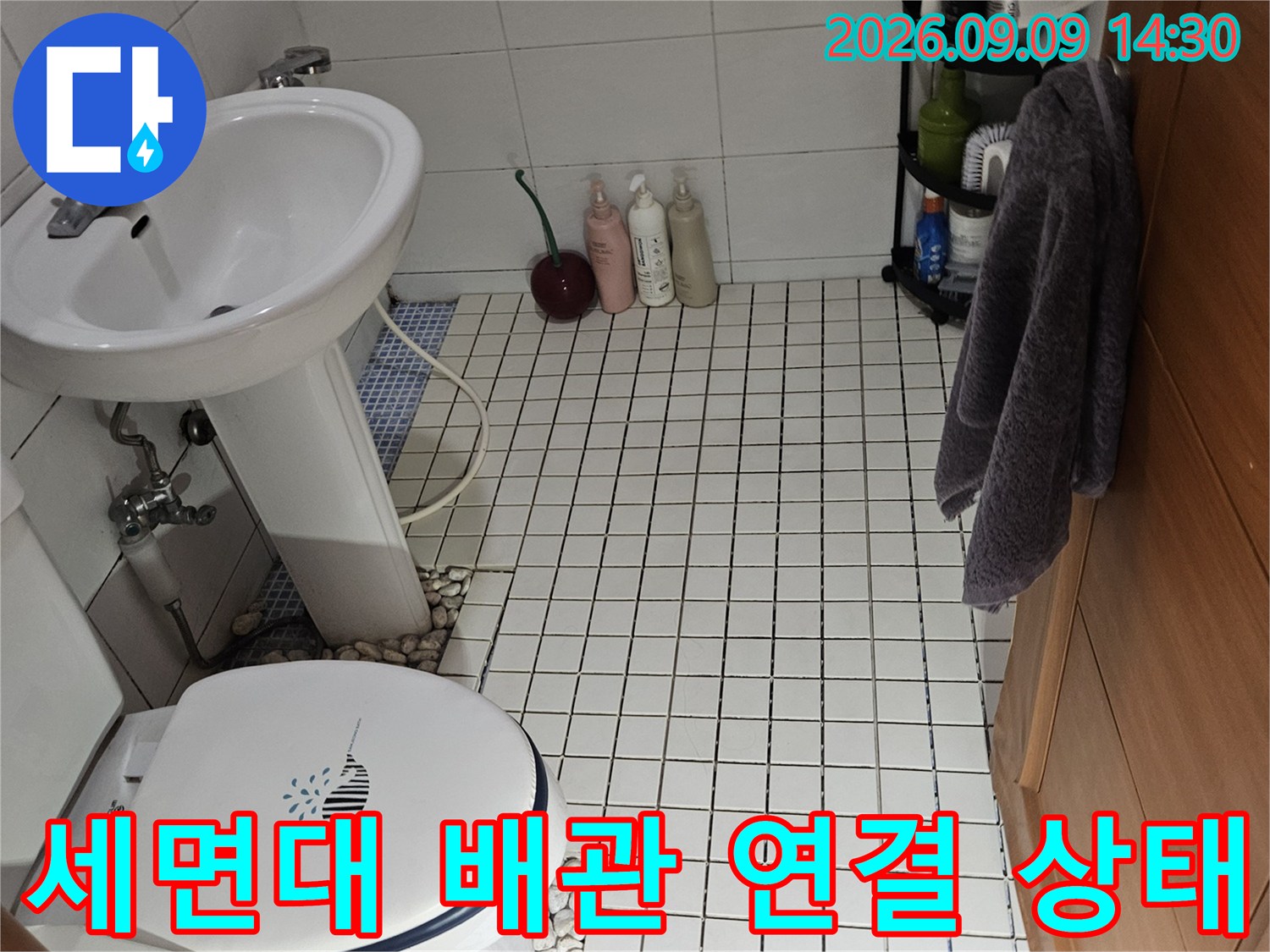 석촌동 욕실 세면대 하단의 밸브와 배수 호스 연결 부위 모습입니다.