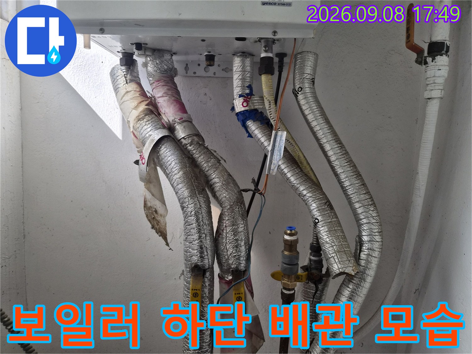 보일러 아래 은색 보온재가 씌워진 배관들의 상세 사진입니다.