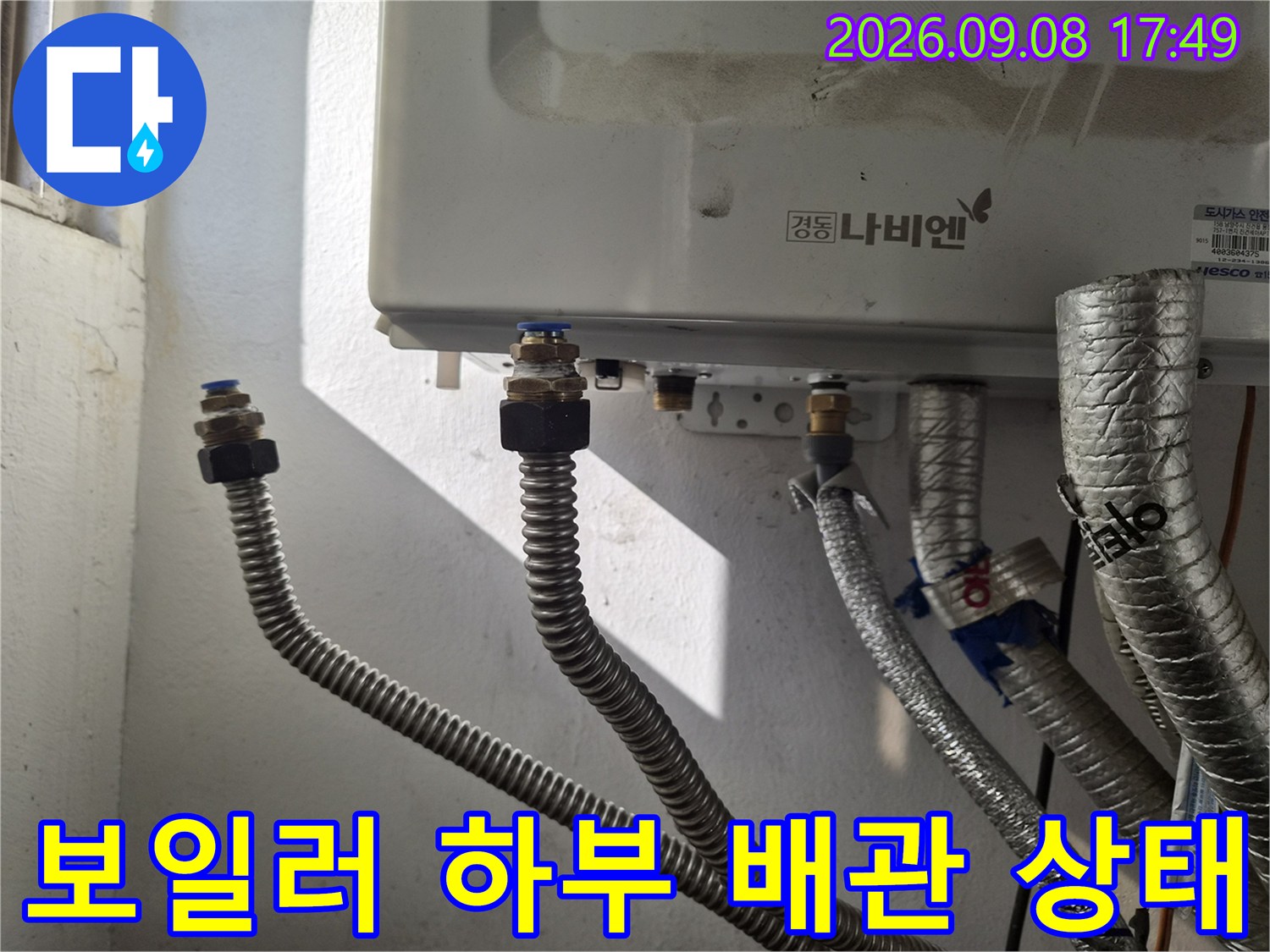 보일러 아래쪽-은색 주름관과 금속 연결 부품 사진